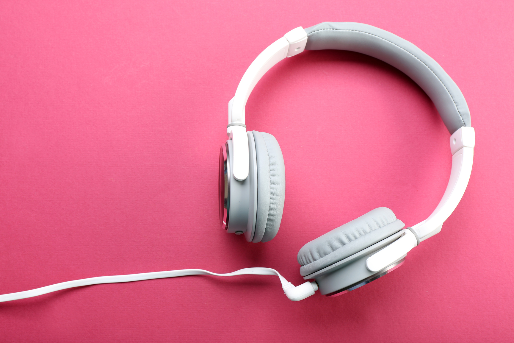 White and Grey Headphones on Pink Background